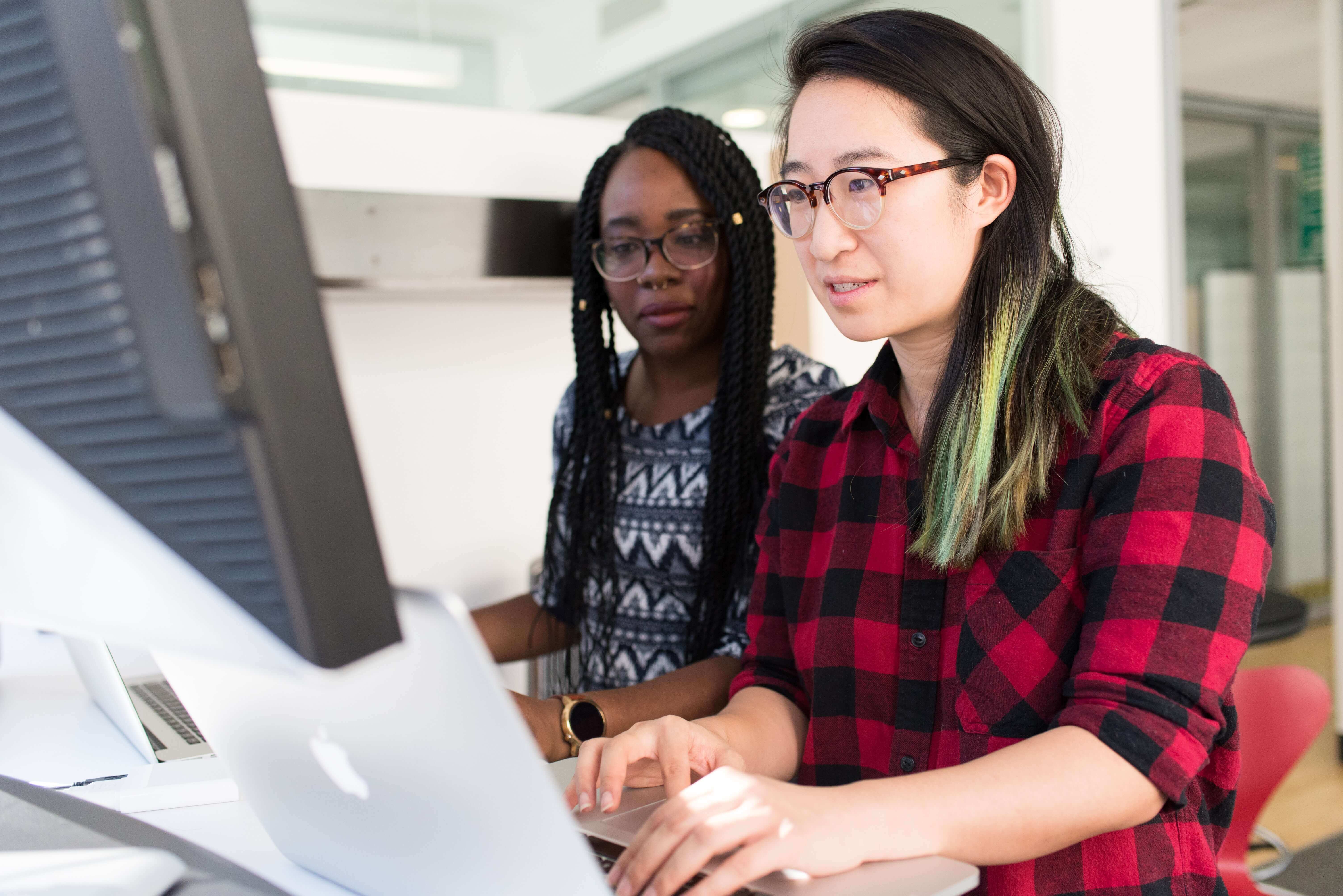 Two people viewing a laptop screen