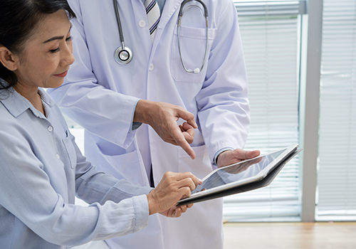 2 medical workers viewing a tablet screen